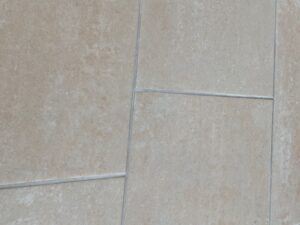 Beige Bodenplatten wo die sauberen Fugen ersichtlich sind.