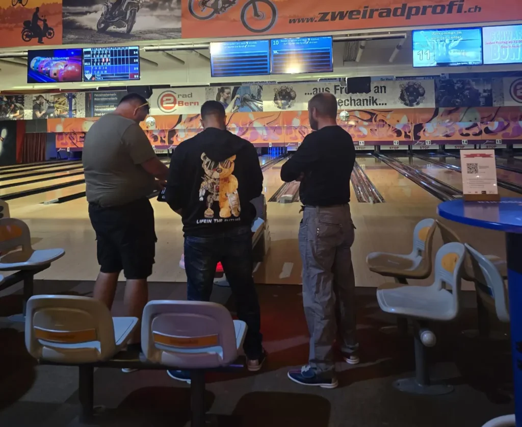 Drei Personen spielen Bowling im Rubigen Center.